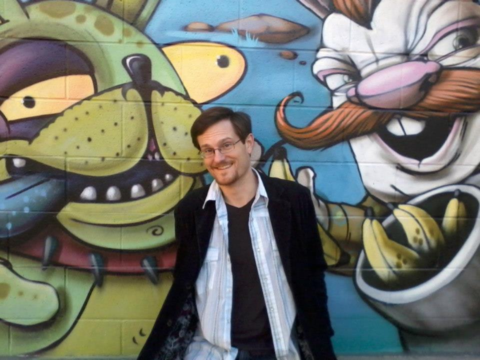 Alex Smith, photographed in front of a mural.